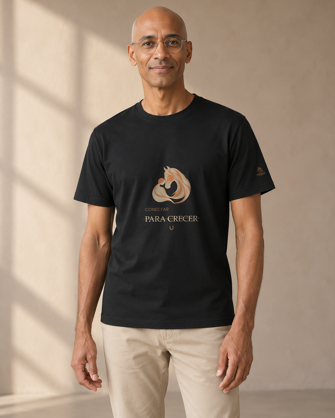 Persona generada con IA mostrando la camiseta negra RIENDAS Asistencia con Caballos para hombre. Representación ilustrativa del diseño Conectar para crecer.