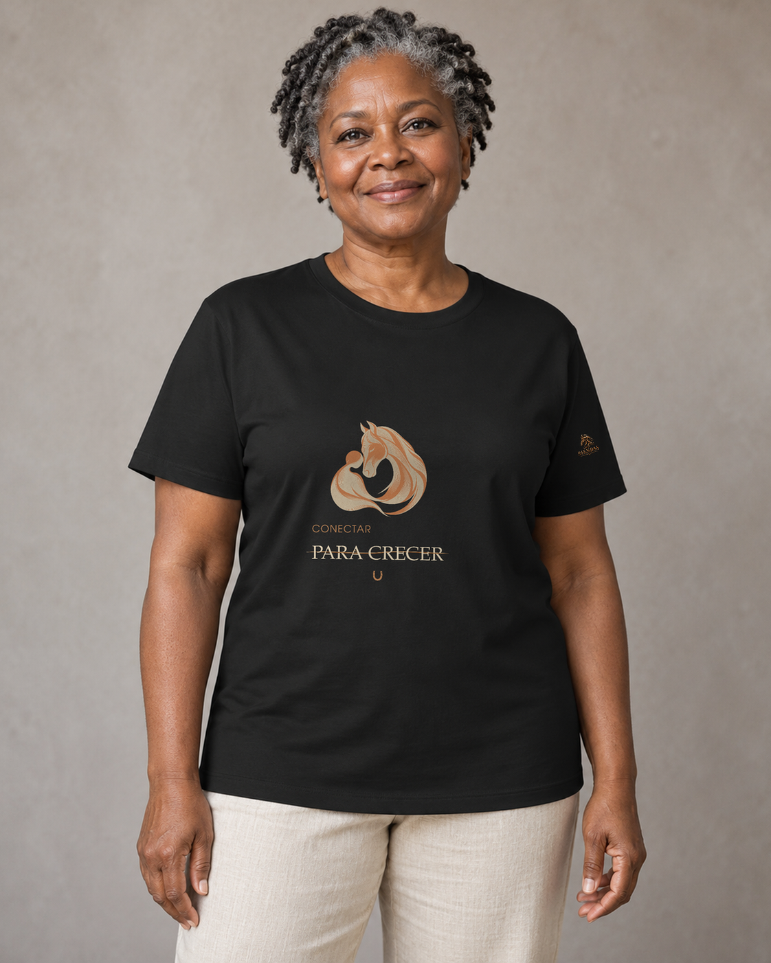 Persona generada con IA mostrando la camiseta negra RIENDAS Asistencia con Caballos para mujer. Representación ilustrativa del diseño Conectar para crecer.